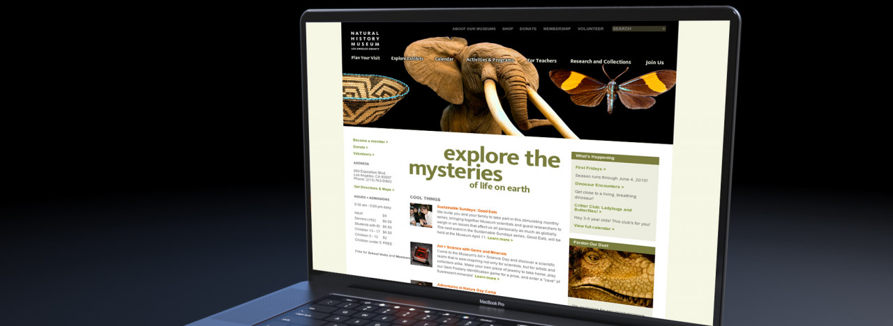 The homepage of NHM's website, displayed on a slick laptop.