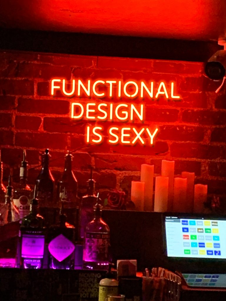 Neon sign in a bar that says "Functional Design is Sexy"