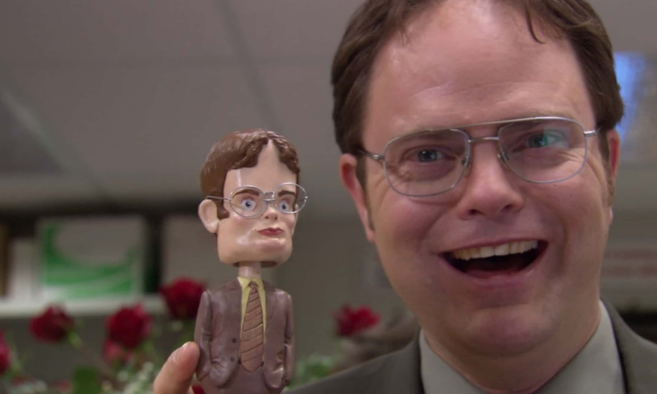 dwight from the office holding a bobblehead