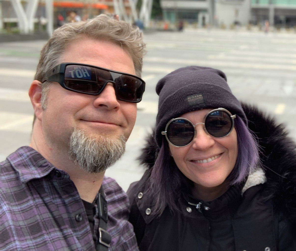A picture of Chris and Wendy, wearing interesting sunglasses and smiling, exploring the urban jungle.